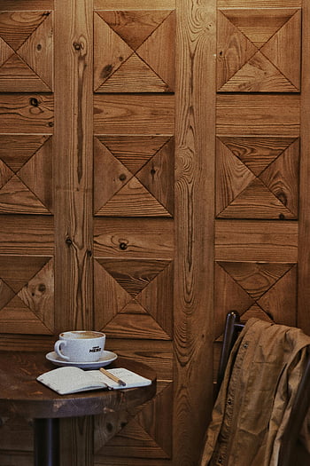 notebook, cappuccino, coffee shop, rustic café, wooden table, textured wall, coffee cup, café setting, wooden interior, cozy atmosphere, coffee break