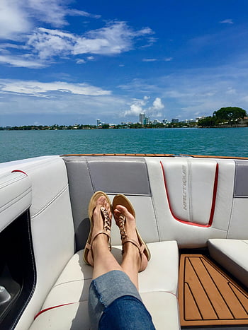 sandales brunes, yacht de luxe, Horizon de la ville, journée ensoleillée, relaxant, intérieur de yacht, vue sur l'eau, sièges extérieurs, pont de bateau, chaussures de sport, temps libre
