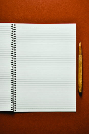 witte notitieblok, open spiraalvormig notitieboekje, houten pen, oranje oppervlak, artistieke presentaties, schoolgerelateerde inhoud, lijntjes papier, studiemateriaal, creatieve werkruimte, opstelling van het bureau, Schrijfhulpmiddelen