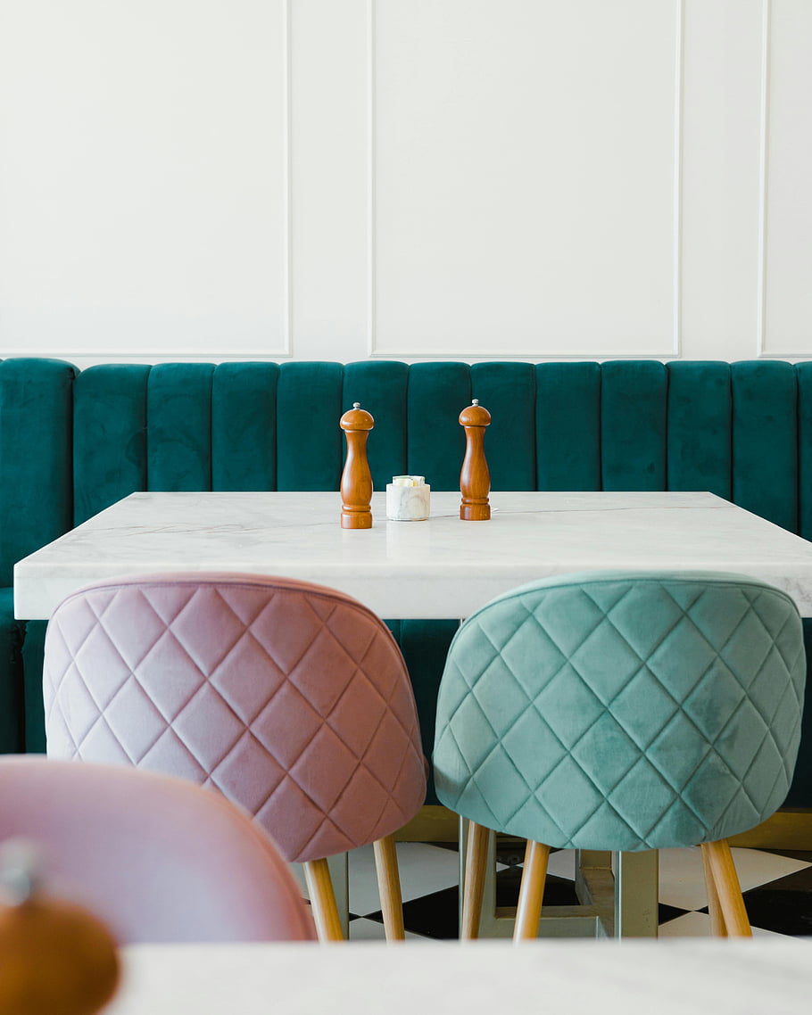 estetická kavárna, Stylová kavárna, Sametové židle, bílý mramorový stůl, elegantní stolování, moderní interiér, Útulné sezení, Výzdoba kavárny, moderní nábytek, pastelové barvy, elegantní nastavení