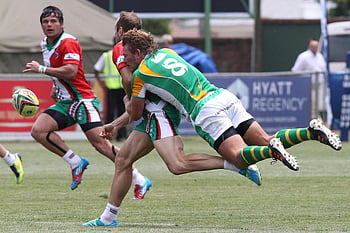 men playing rugby, rugby tackle, competitive match, outdoor rugby, rugby players, intense tackle, rugby ball, sports action, rugby field, rugby uniforms, rugby competition