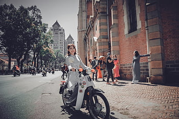 kobieta jedzie motocykl, Skuter w stylu vintage, ulica miasta, architektura miejska, przechodnie, Kobieta na motocyklu, pejzaż miejski, scena miejska, vintage rower, Fotografia uliczna, miejski styl życia