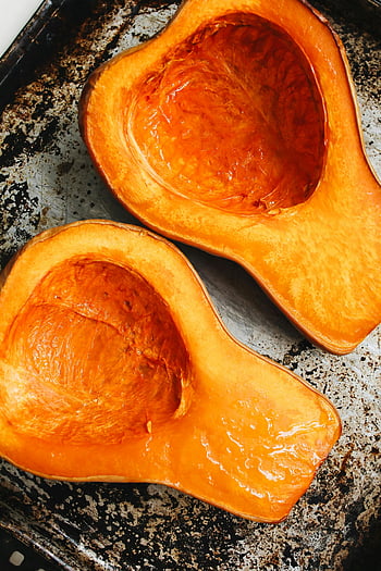 opečená dýně, pečená dýně hokkaido, Squashovy poloviny, rustikální kovový plech na pečení, pohled shora, pečená dýně, ořešák squash, recept na dýni, dýňový pokrm, Příprava tykve, detailní záběr na dýni