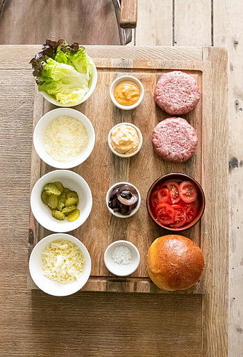 버거 성분, 나무 테이블, 나무 도마, 햄버거 패티, 상추, 치즈, 절인 것, 토마토, 양파, 마요네즈, 소금