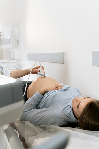 zwangere vrouw, echografie, kliniekomgeving, medisch onderzoek, prenatale zorg, Medisch professional, medische uitrusting, Foetale ontwikkeling, Moeder in verwachting, medische echografie, gezondheidszorg