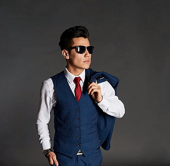 man in blauw pak, Stijlvolle man, zonnebril, zelfverzekerde pose, binnenshuis portret, grijze muur, formele kleding, rode das, wit overhemd, vest, kijk maar