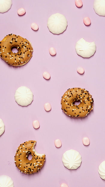 donuts, white icing, flat lay, pastel pink background, food photography, dessert themes, candies, sprinkles, meringues, creative composition, sweet treats