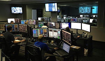 software engineers, working on computers, bustling control room, multiple computer monitors, people working, control room, computer monitors, software development, team collaboration, technology workspace, busy office