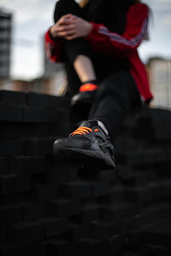 Nike Nike Air Huarache, Lacci arancioni, contesto urbano, streetwear casual, scarpe da ginnastica nere, avvicinamento, Sneaker eleganti, moda urbana, stile di strada, scarpe da ginnastica Nike, scarpe nere