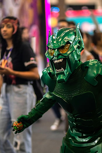 Green Goblin costume, cosplayer, São Paulo festival, dynamic shot, green villain costume, cosplay event, comic convention, character costume, festival attendees, action pose, detailed costume