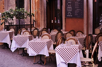 Italian restaurant, checkered tablecloths, outdoor seating, cozy restaurant, empty tables, street dining, inviting atmosphere, restaurant exterior, checkered patterns, outdoor tables, Italian dining