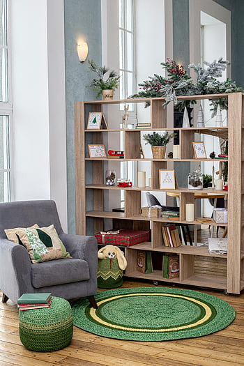 gray sofa chair, brown wooden shelf, modern bookshelves, stylish living room, decorative elements, armchair, green rug, wooden floor, cozy interior, holiday decor, festive decorations