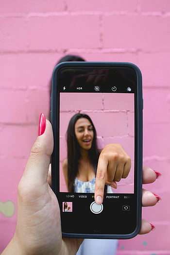 selfie, smartfon, różowa ściana, kobieta, iPhone, przechwytywanie, wibrujący, zdjęcie, trzymać, tryb portretowy, wskazywanie palcem