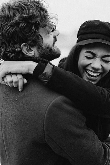 einfarbiges Foto, Paar lacht, Schwarz und weiß, freudiges Paar, Paar umarmen, liebevoller Moment, Schwarzweiss-Bild, glückliches Paar, Romantisches Foto, Emotionales Foto, offener Moment