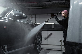 woman, cleaning, black car, pressure hose, power washing, indoor garage, high-pressure washer, car wash, auto care, vehicle maintenance, garage cleaning