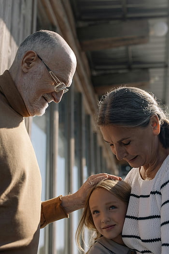 elderly couple, granddaughter, family bonding, tender moment, love, indoor scene, grandparents and grandchild, multi-generation family, tender interaction, affectionate moment, togetherness