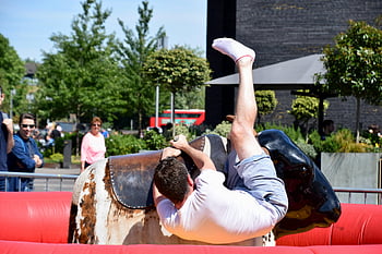 Muž na koni býka, mechanický býk, Park Event, Londýn, mladý muž, Napínavá jízda, venkovní aktivita, zábavní park, býk na koni, Mechanická jízda býků, veřejné akce