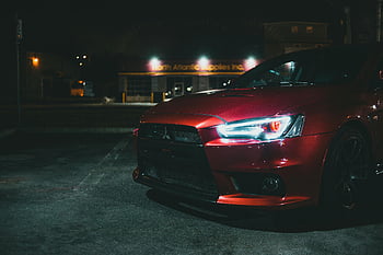 Červený Mitsubishi Lancer Evo, detailní fotografie, auto reflektor, noční scénu, moderní design, auto detail, auto Mitsubishi, jasný světlomet, automobilové fotografie, červené auto, noční fotografie