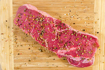 raw meat, beige wooden surface, raw steak, spices, wooden cutting board, cooking inspiration, close-up, seasoning, uncooked beef, food preparation, culinary arts