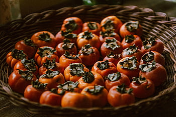 persimmons, close-up view, fresh persimmons, wicker basket, vibrant colors, autumn vibes, seasonal fruits, orange fruits, healthy snacks, fruit photography, autumn harvest
