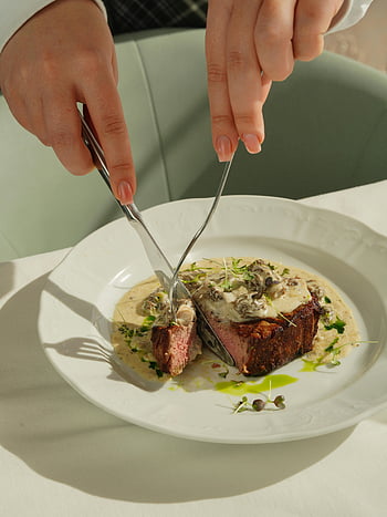 donna che taglia la carne, carne arrostita, salsa cremosa di funghi, bistecca, avvicinamento, cenare, fotografia di cibo, pasto gourmet, piatto placcato, arte culinaria, cucina raffinata