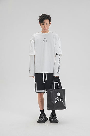 Człowiek w odzieży sportowej, Białe studio, monochromatyczna odzież sportowa, torba firmowa, Moda studyjna, Modny mężczyzna, Projekt czaszki, czarne spodenki, Biała koszulka, Pozycja studyjna, torba na zakupy