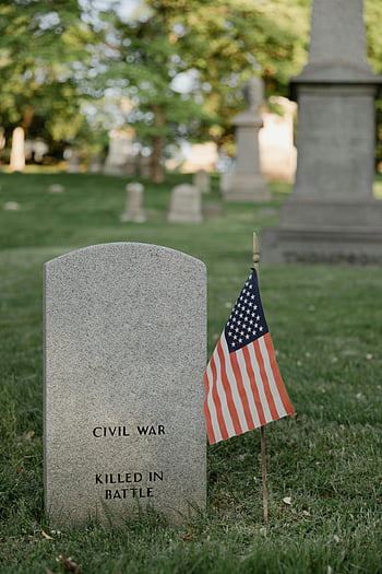 American flag, gray tombstone, Civil War, veteran grave, serene cemetery, killed in battle, memorial site, historical cemetery, American history, military grave, flag decoration