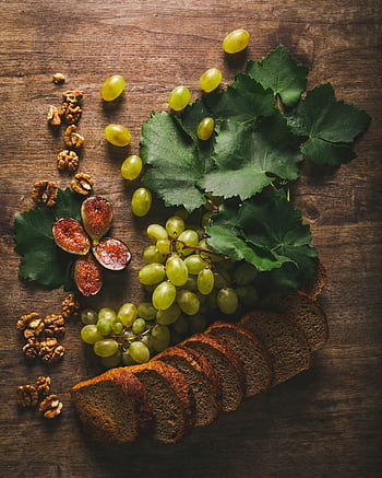 zelené hrozny, krájený chleba, fíky, vlašské ořechy, Rustikální zátiší, dřevěný stůl, zdravé jídlo, přírodní ingredience, podzimní sklizeň, ovoce a ořechy, řemeslný chléb