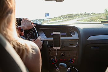 Nő vezetés, autó belső, napos nap, telefonra szerelt telefon, Irányítópult, kormánykerék, jármű, kirándulás, sofőr nézete, autóutazás, napos idő