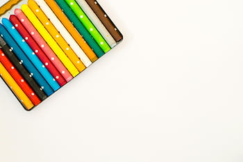 colorful crayons, white background, creativity, multi-colored pencils, neatly arranged, art supplies, vibrant colors, drawing tools, educational materials, flat lay, minimalist design