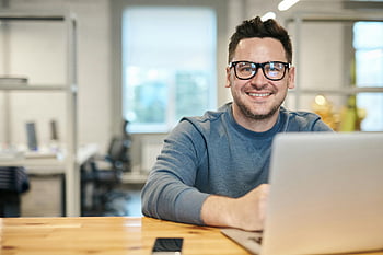 uomo che indossa occhiali, uomo felice, lavorando da remoto, il computer portatile, ufficio moderno, ambiente di ufficio, occhiali, lavoro a distanza, impostazione professionale, uomo sorridente, abbigliamento casual