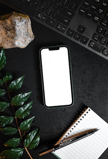 smartphone, keyboard, notepad, leaves, black surface, tech themes, productivity themes, top view, smartphone near keyboard, office setup, workspace arrangement