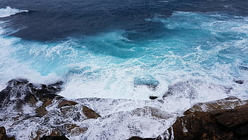 Ozean Wellen, felsige Kueste, High-Winkel-Schuss, natürliche Schönheit, Wasserspritzen, Dynamische Szene, Küstenlandschaft, Wellencrash, blaues Meer, weißer Schaum, schroffen Felsen