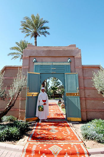 marrakech, marocký, tradiční oděv, přivítání muže, živý vchod, brána, palma, červený koberec, kulturní zážitek, marocké architektury, usmívající se muž