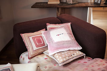 cozy indoor scene, modern sofa, stylish pink cushions, beige cushions, assorted-color throw pillows, padded red sofa, indoor decor, living room furniture, home decor, comfortable seating, decorative pillows