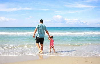 father and daughter, walking on beach, family time, sunny beach, holding hands, ocean waves, beach scene, summer vacation, father-daughter bonding, beach walk, family beach day