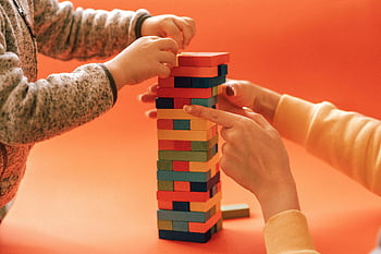 母と子、 レンガを組み立てる、 カラフルな木製ブロック、 学習と創造性、 オレンジ色の背景、 家族の活動、 教育のおもちゃ、 インタラクティブなプレイ、 ビルディングブロック、 子どもの発達、 大人と子供の交流