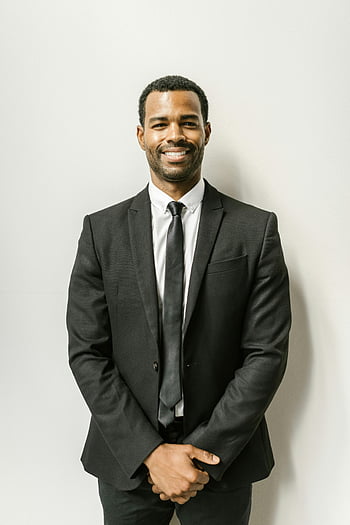 man in black suit, smiling man, formal attire, confident man, white wall, professional portrait, business attire, black suit, white background, professional look, smiling at camera