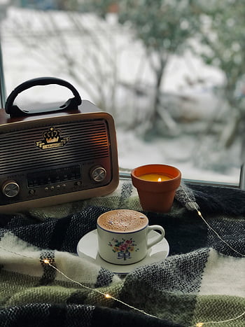 radio vintage, tasse de café, bougie allumée, cadre hivernal confortable, Ambiance chaleureuse, scène invitante, décor d'hiver, décor vintage, après-midis douillets, tasse à café, Ambiance aux chandelles