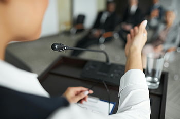 話している人、 白い長袖、 マイクロフォン、 表彰台、 ビジネスミーティング、 観客、 会議室、 プロの環境、 人前で話す、 プレゼンテーション、 フォーマルイベント