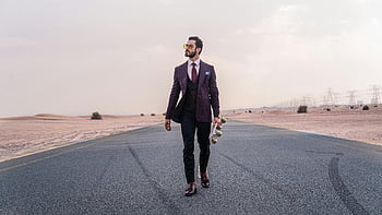 man walking, formal wear, deserted road, holding skateboard, stylish fashion, desert setting, man in suit, skateboard, desert road, fashion style, man walking road