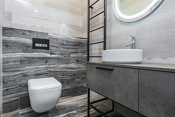 Moderní toaleta, Elegantní koupelna, šedé dlaždice, Stylový dřez, minimalistický design, moderní koupelna, kulaté zrcadlo, Toaleta na stěně, Plovoucí dřez, Moderní marnost