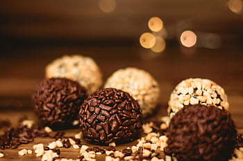 kulaté čokoládové dezerty, dřevěný stůl, různé brigadeiros, čokoládové ořechy, Brazilský dezert, detail, čokoládové pochoutky, Brigadeiro bonbóny, Dezertní fotografie, fotografování potravin