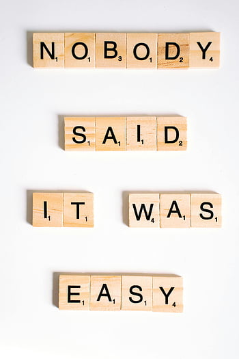 piastrelle di Scrabble, superficie bianca, colpo del primo piano, nessuno ha detto che sarebbe stato facile, citazione motivazionale, piastrelle di legno, pezzi di gioco, messaggio ispiratore, tessere di lettere, sfondo bianco, gioco di scrabble