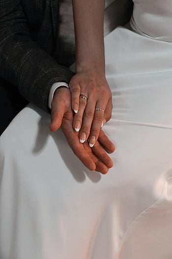 couple holding hands, newlywed couple, wedding rings, close-up photo, wedding day, bride and groom, engagement rings, wedding attire, romantic moment, hand in hand, newly married
