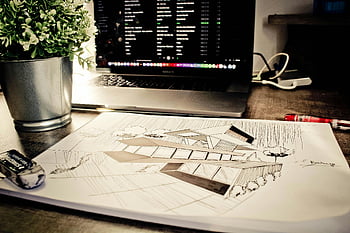 house sketch, eraser, architectural sketch, desk, laptop, plant, office setting, drawing tools, workspace, design process, creativity