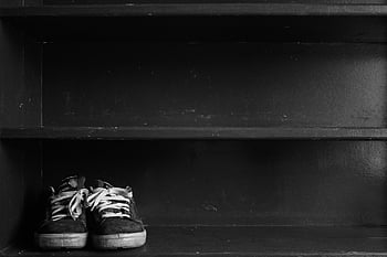 black-and-white sneakers, low-top sneakers, dark wooden shelf, monochrome shot, ample copyspace, black and white shoes, sneaker display, black sneakers, white sneakers, shoe rack, minimalist photography
