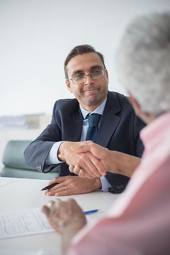 businessmen shaking hands, office setting, successful business deal, man in black suit jacket, wearing eyeglasses, professional meeting, business agreement, formal handshake, corporate environment, business attire, office interaction
