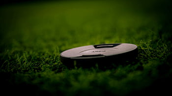 Sigma lens cap, black camera lens cover, green grass, close-up photography, nature photography, detailed close-up, lush green grass, camera lens cover, outdoor photography, Sigma lens, lens cap on grass
