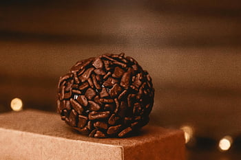Brazilský brigadeiro, hnědý kulatý dezert, čokoládová textura, hnědý povrch, detailní fotografie, Čokoládová chuť, Dezertní fotografie, fotografování potravin, čokoládové cukrovinky, hnědé pamlsky, recept na brigadeiro